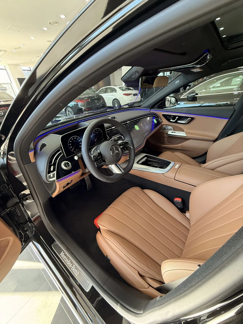 운전석 도어를 연 E300 4MATIC AMG Line 실내, 앰비언트 라이트와 브라운 가죽 시트