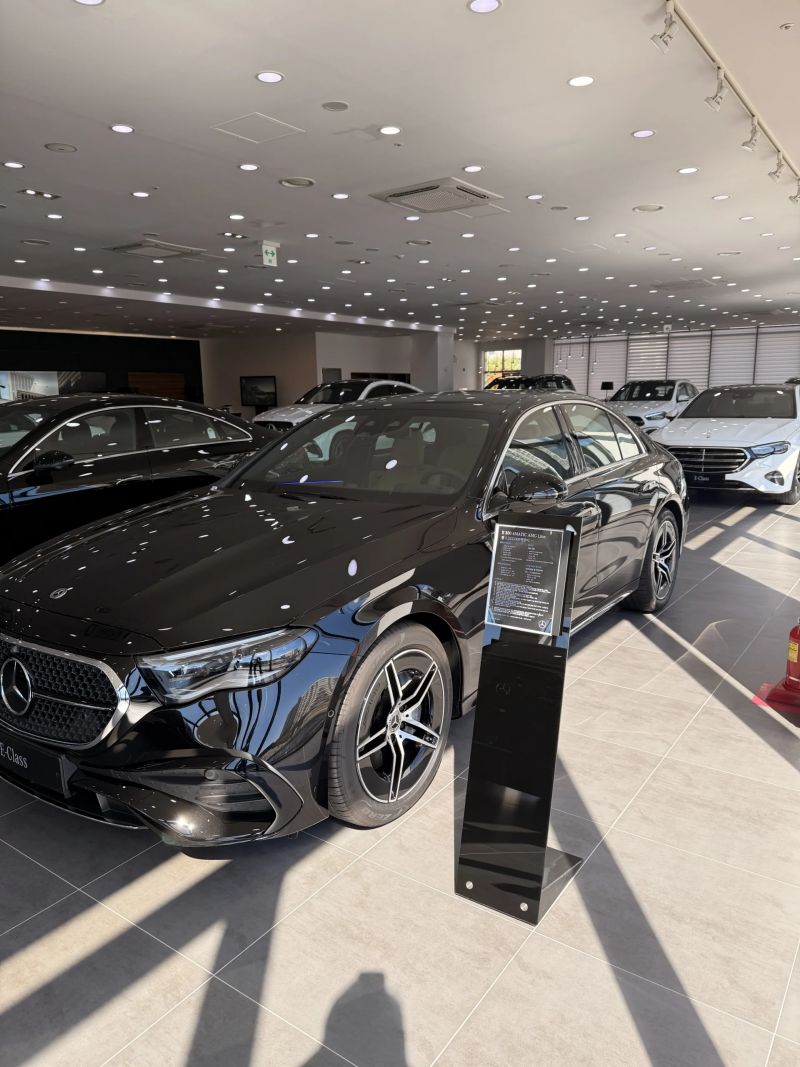 전시장 안내 스탠드 옆에 전시된 E300 4MATIC AMG Line 앞쪽 측면
