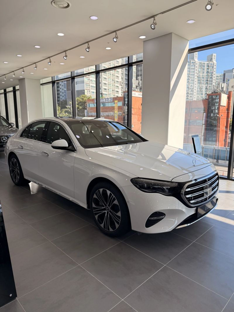 E 350 e 4M EX 별도 모델, 전시장에 놓인 화이트 차량의 앞 3/4 측면